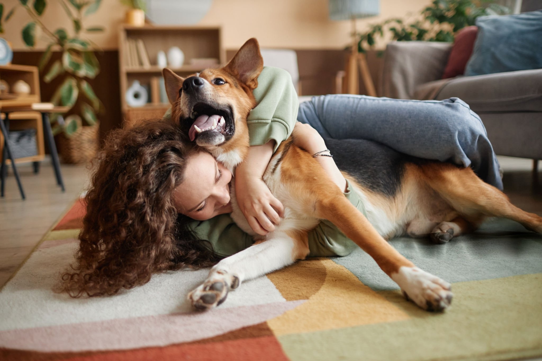 Mujer jugando con su perro. Trucos para ahorrar dinero con tu mascota